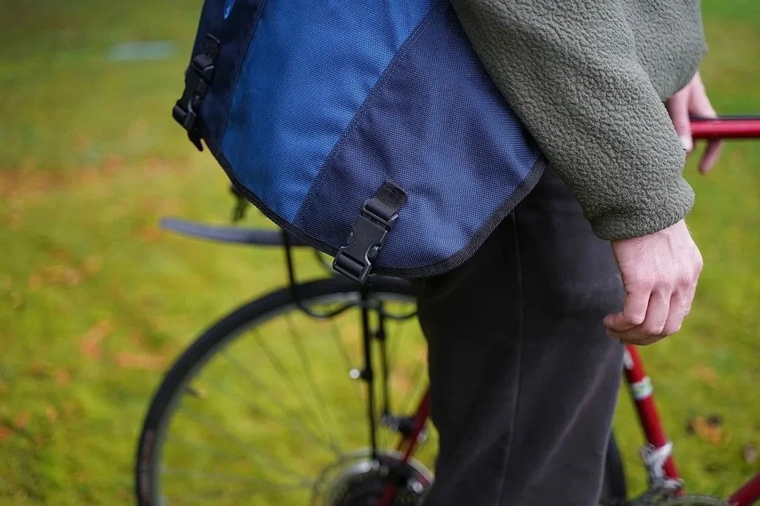 Close-up of a person with Cinch Side-Release SR Series buckle on messenger bag.