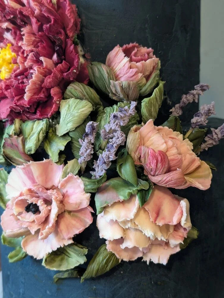 Close-up of navy blue luxury bespoke wedding cake showing the detail of the hand-sculpted white chocolate flowers. 