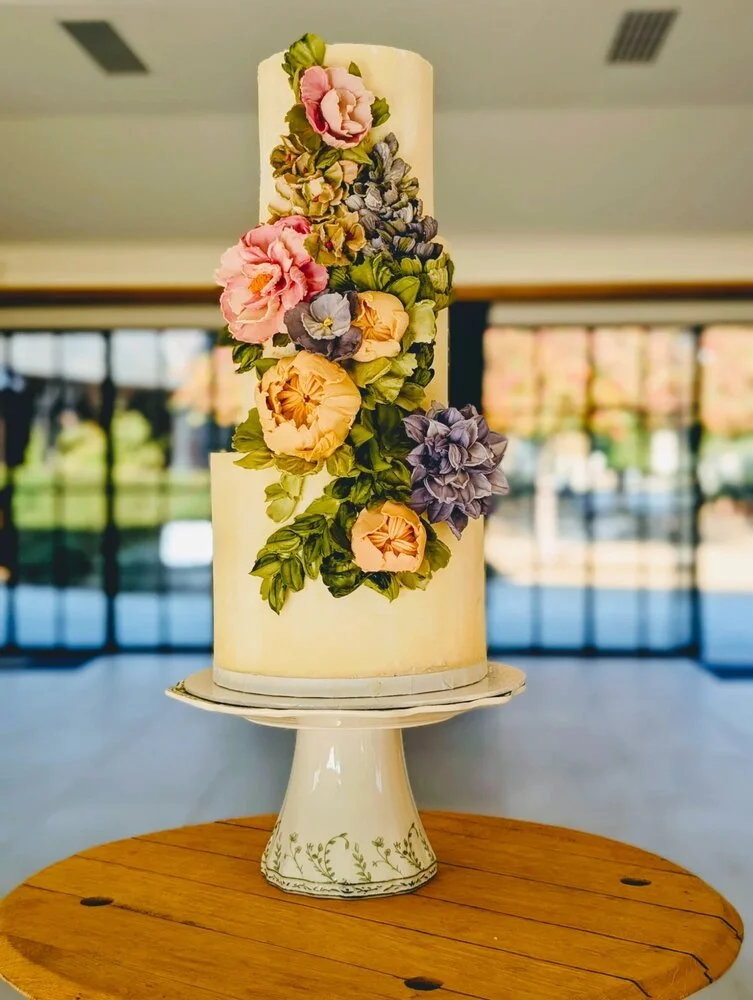A three-tier bespoke luxury hand-sculpted white chocolate wedding cake.