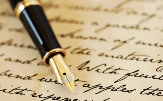 A fountain pen resting on handwritten cursive paper.