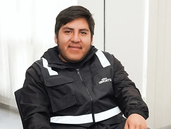 Joven sentado en una oficina con ropa de seguridad negra y blanca