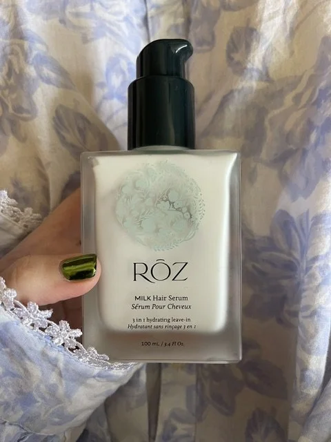 SERA SLOANE HOLDING MILK HAIR SERUM, GREEN NAIL POLISH AND FLORAL DRESS