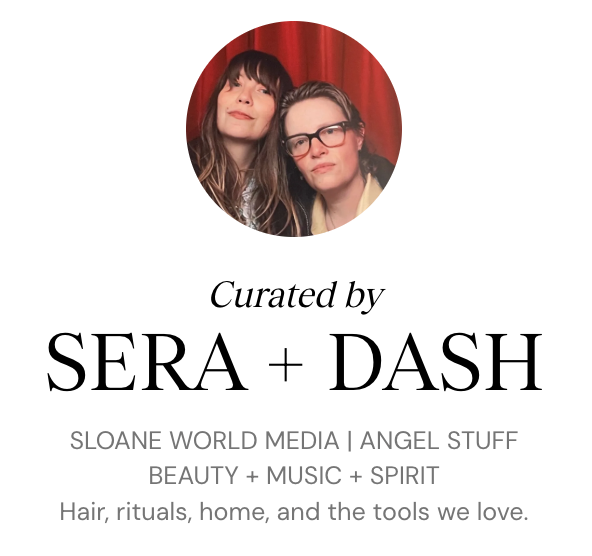 Image sera sloane and dash lippman, los angeles lgbtq vinyl dj duo, posing in front of a red curtain at an event titled "Curated by SERA + DASH", related to media, beauty, music, spirit, hair, rituals, home, and tools.