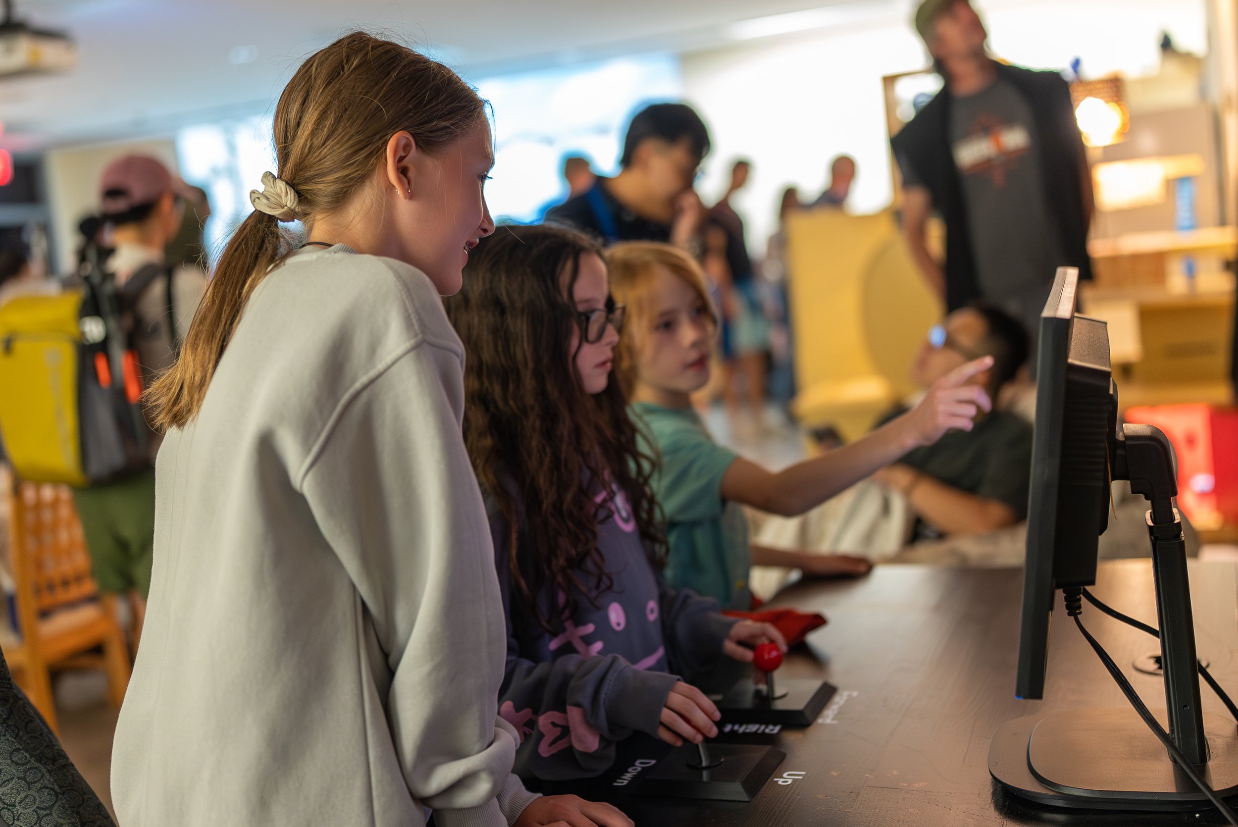 A crowd of children investigates the video game