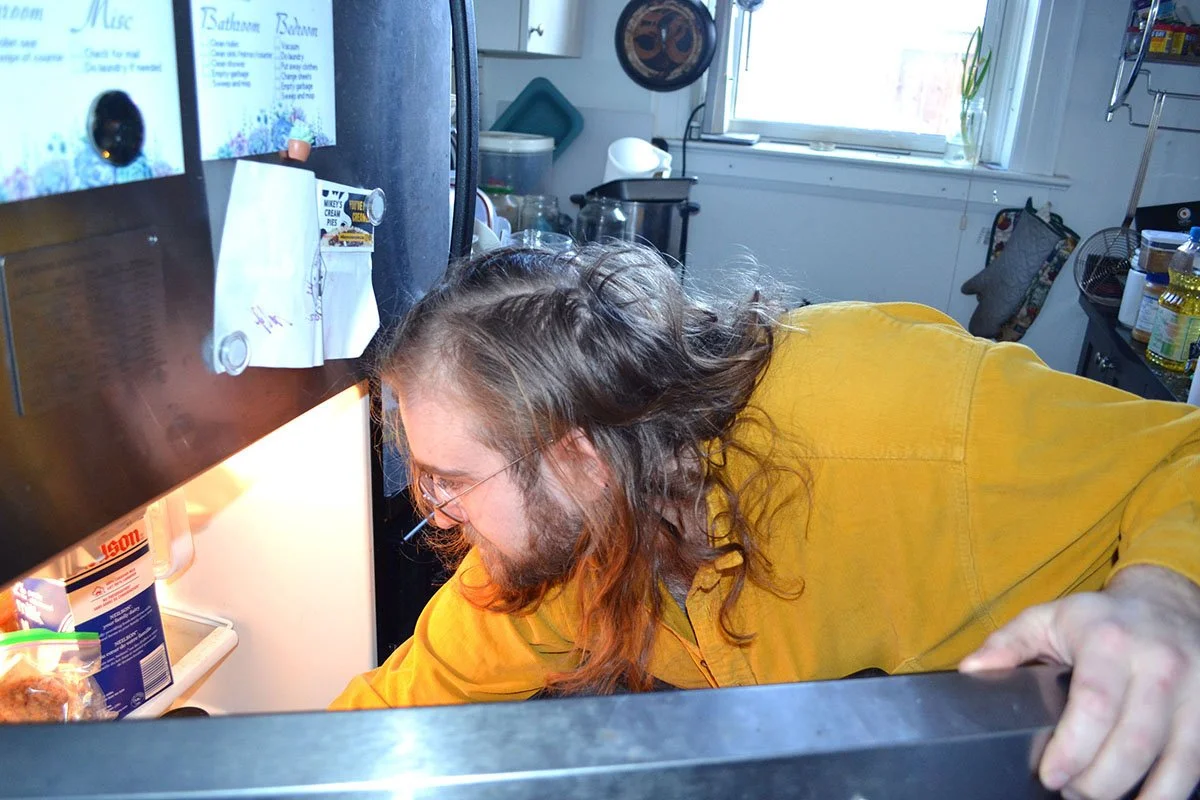 Birch Switch reaching into the refrigerator to make lunch