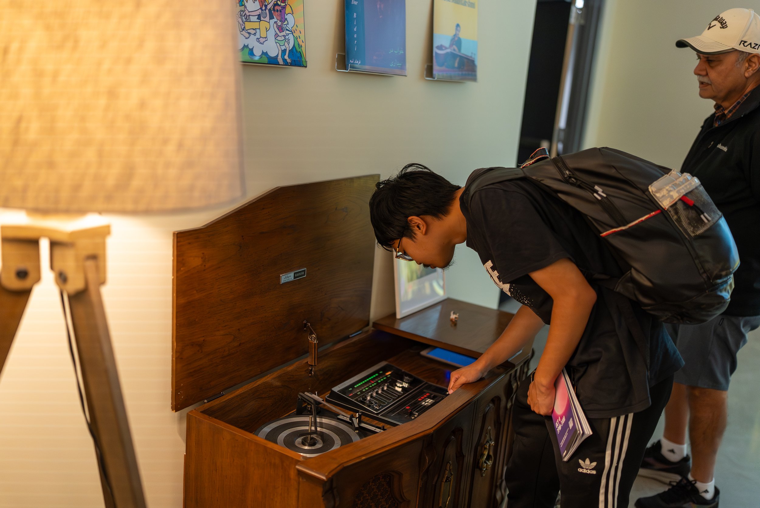 A young man investigating a vintage record player/radio
