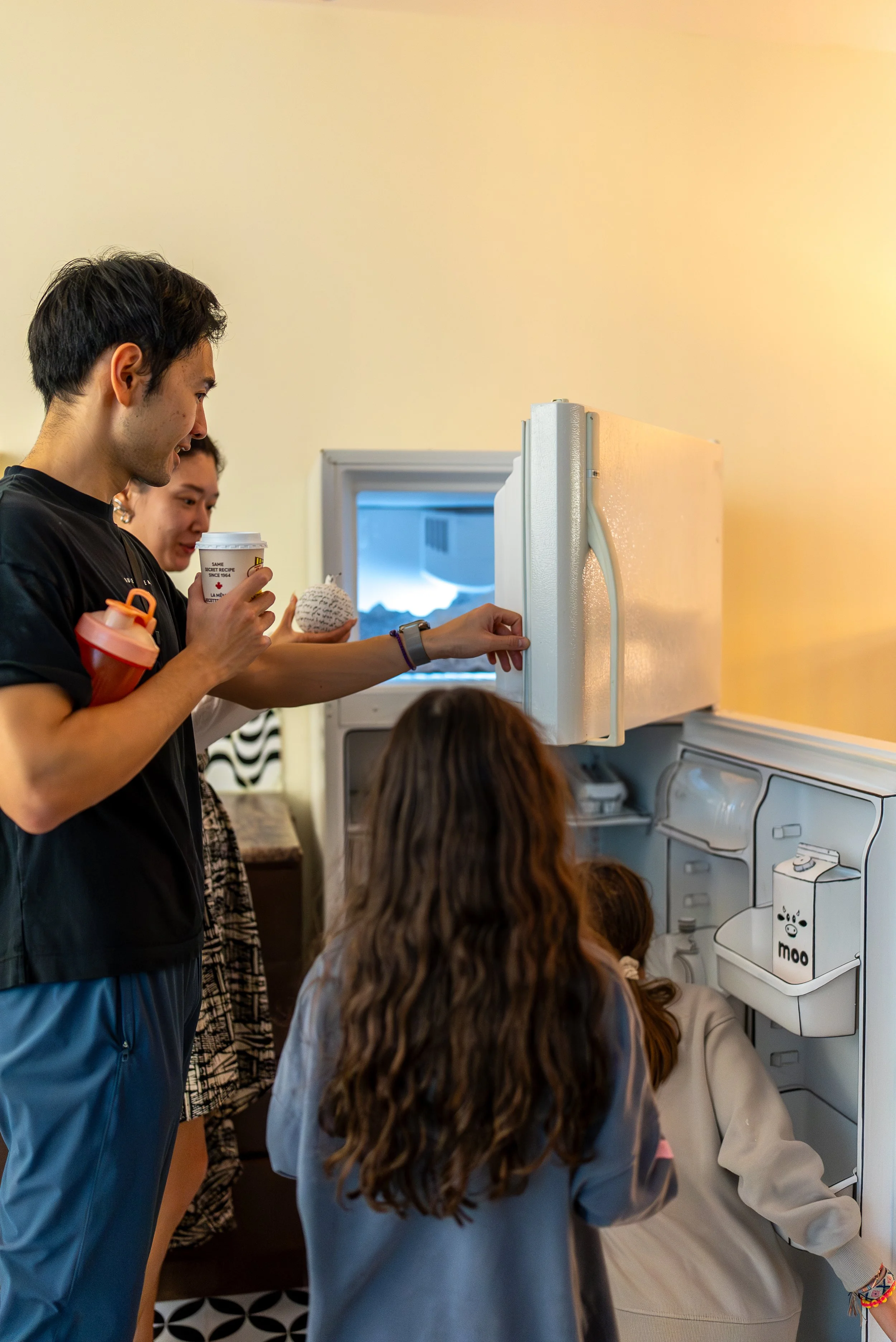A crowd investigates a surreal refrigerator