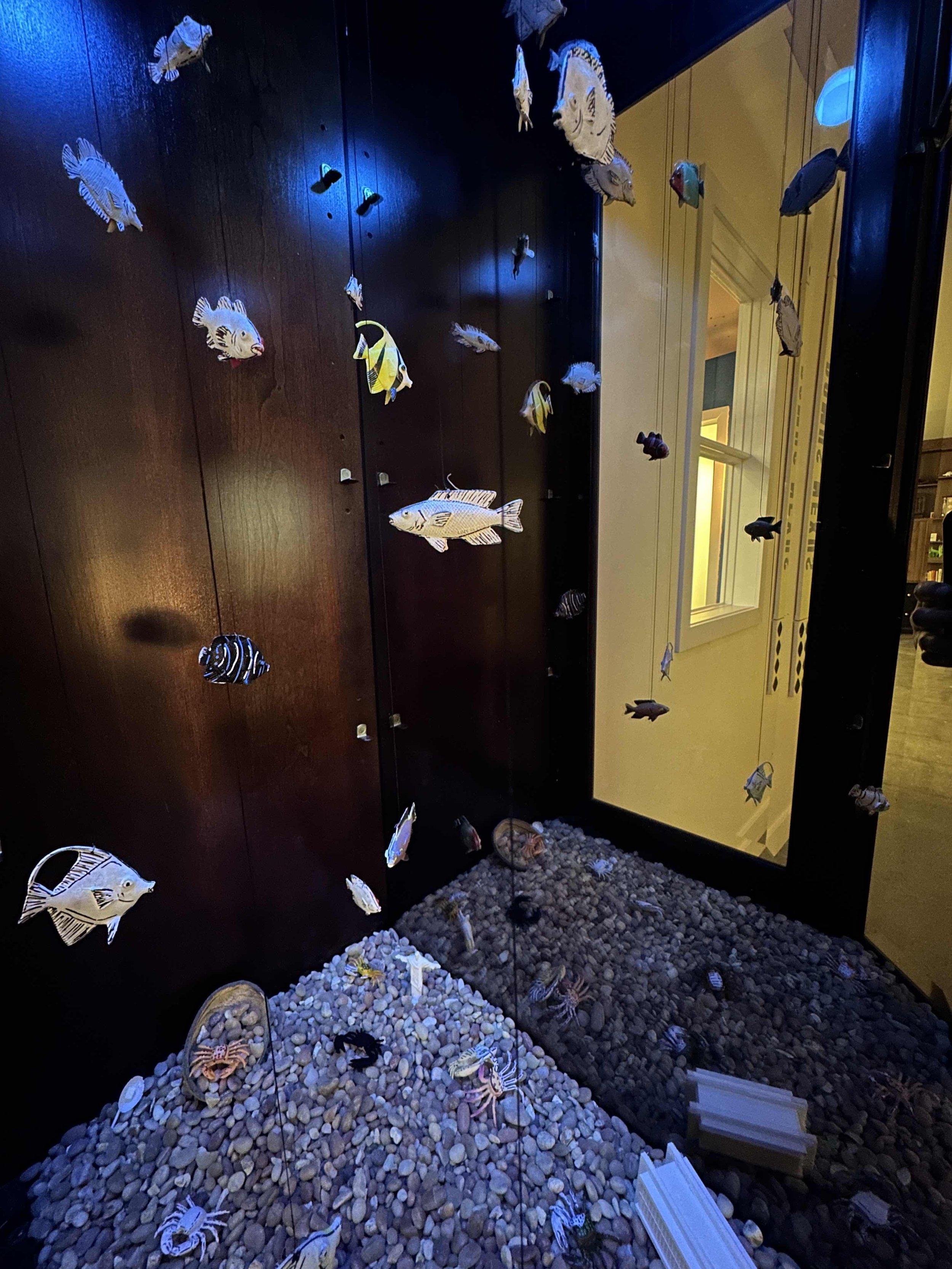 A fish tank with tiny stationary fish inside a hutch