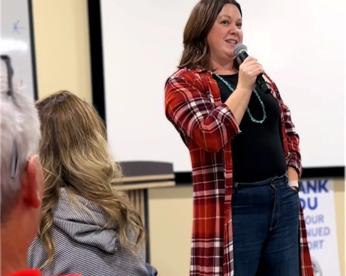 Irene speaking at an event into a microphone.