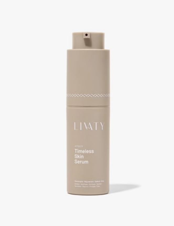 A beige bottle of LITTY Timeless Skin Serum with a spray nozzle, minimalistic design, and a subtle decorative band near the top.