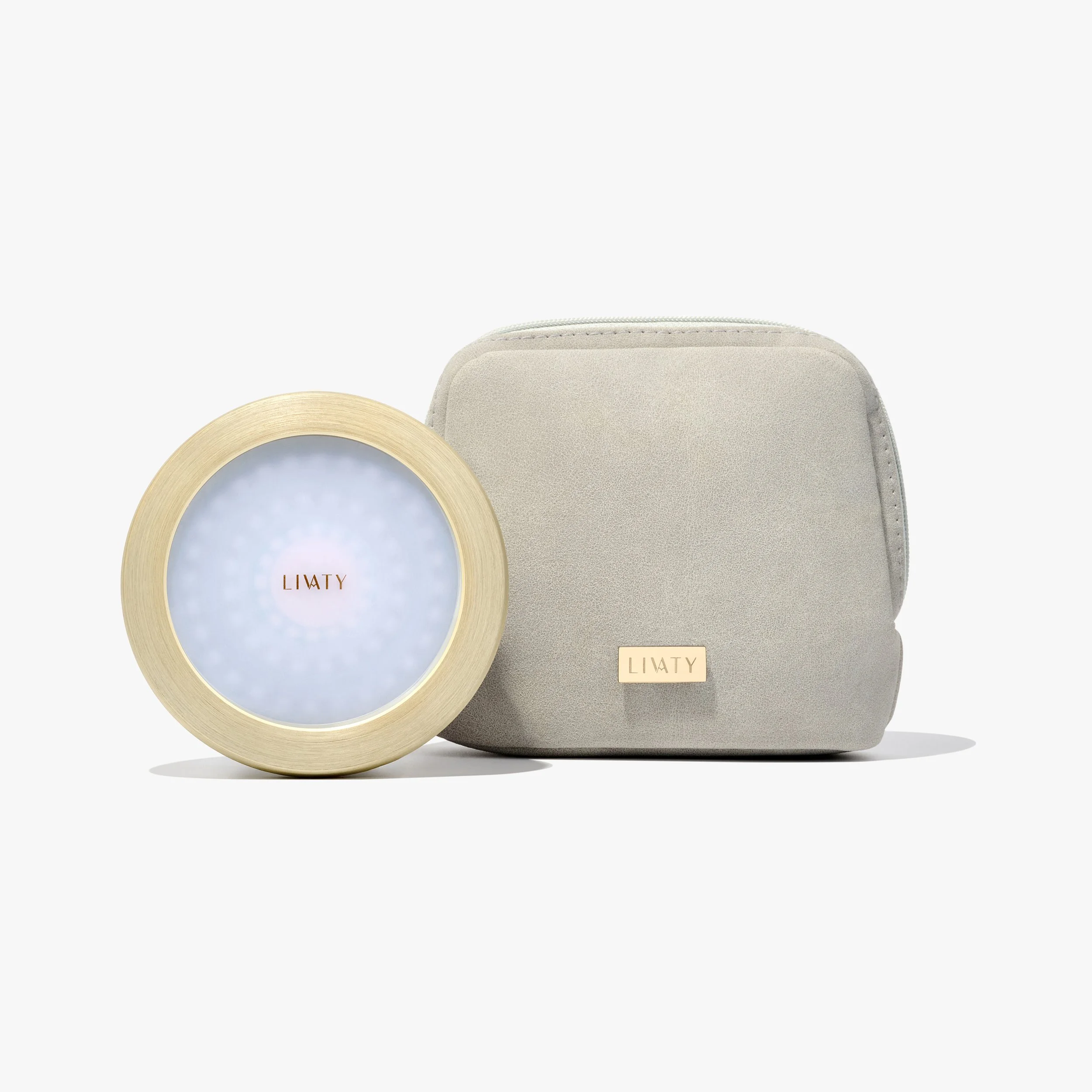 A round light therapy device with a gold rim, displaying the brand name Livaty, next to a light gray fabric carrying case with a gold Livaty logo on it.