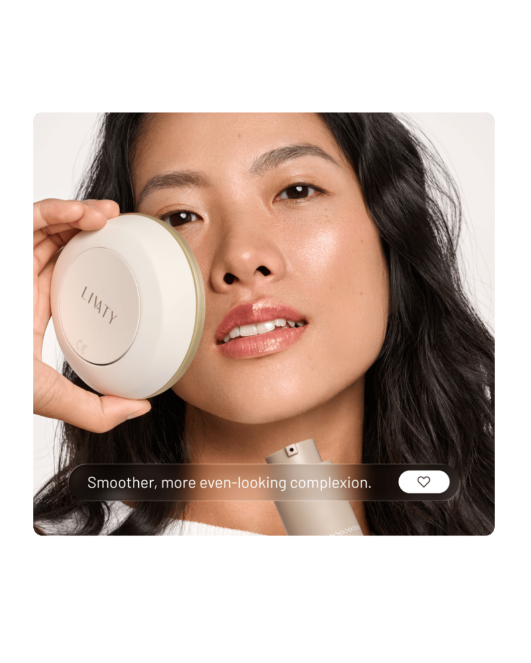 Close-up of a woman with dark wavy hair holding a round skin care device labeled "LIATY" to her face, with a bottle of skincare product nearby. The caption reads "Smoother, more even-looking complexion."