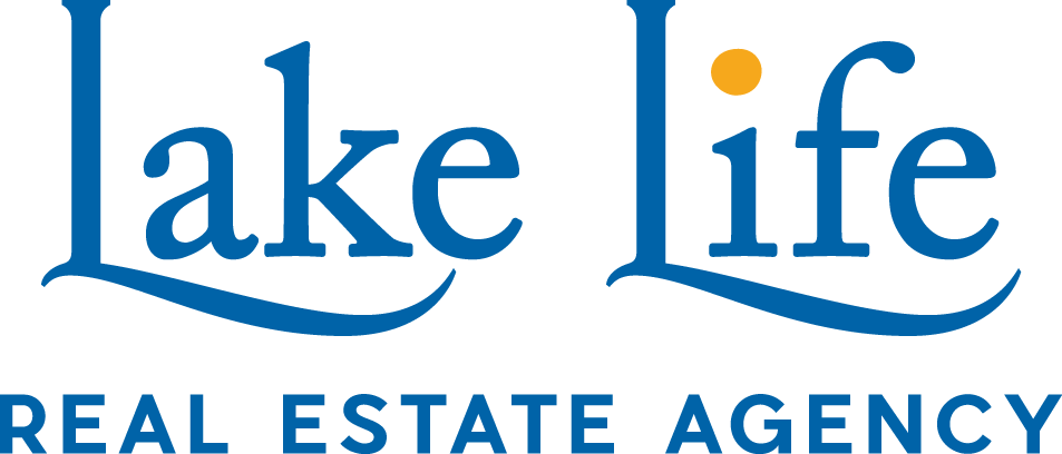 Logo for Lake Life Real Estate Agency with blue text, a yellow dot over the 'i' in 'life', and stylized wave lines beneath the words.