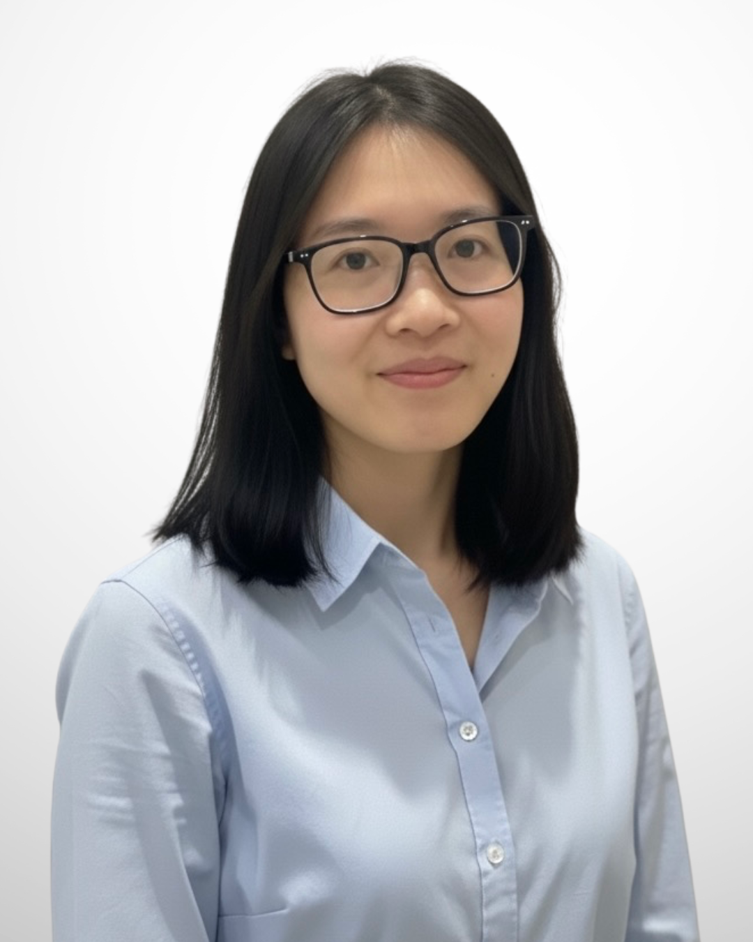 A woman with shoulder-length black hair and glasses, wearing a white button-up shirt, smiling against a plain white background.