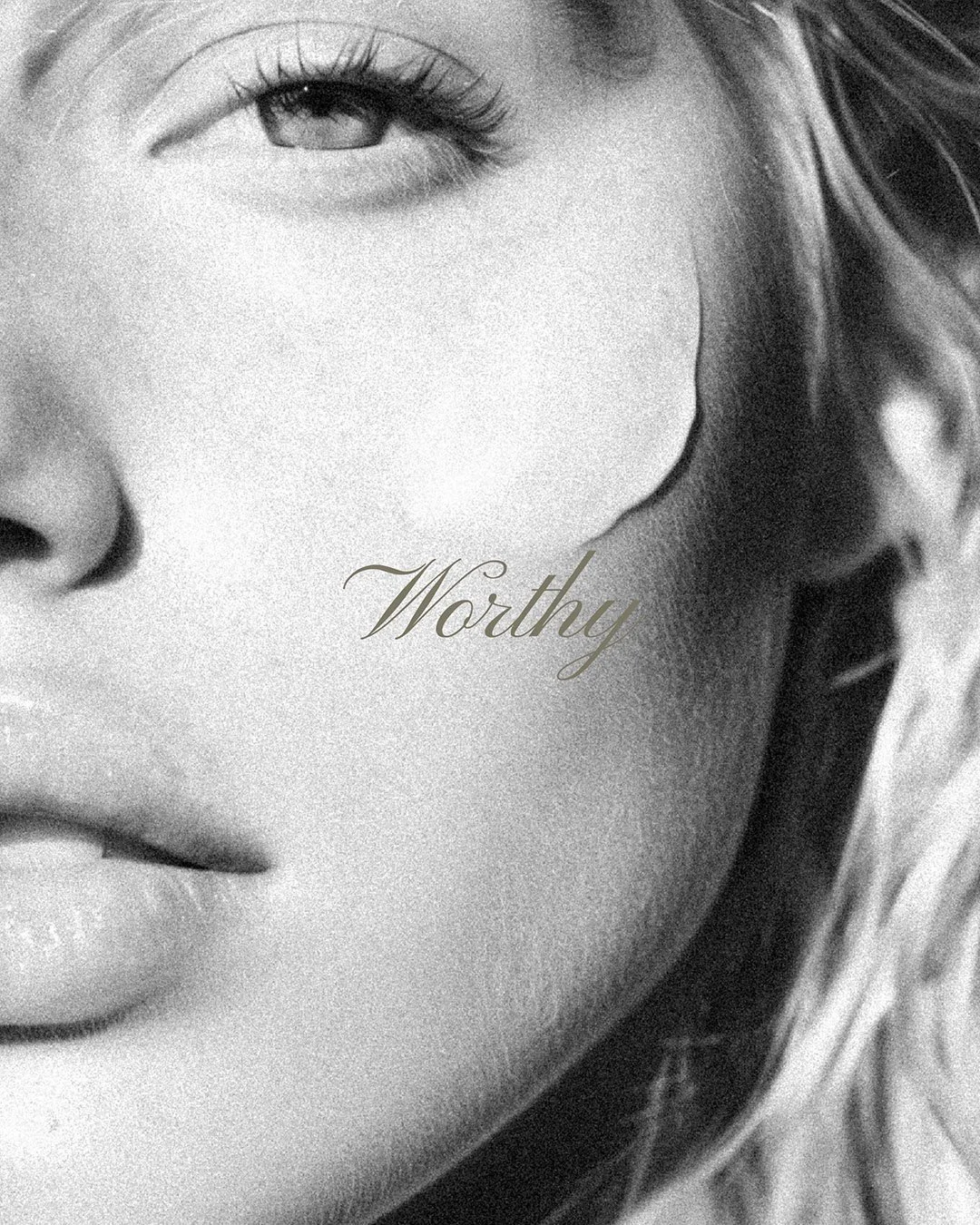 Heritage Club black and white image of half of womans face with the word 'Worthy' over the cheek bone in italic.