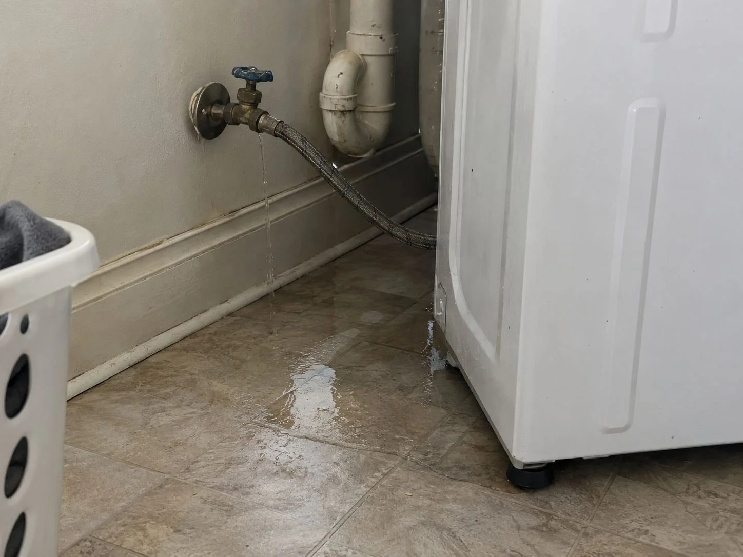 Leaking washing machine hose on a laundry room floor in Mission, KS