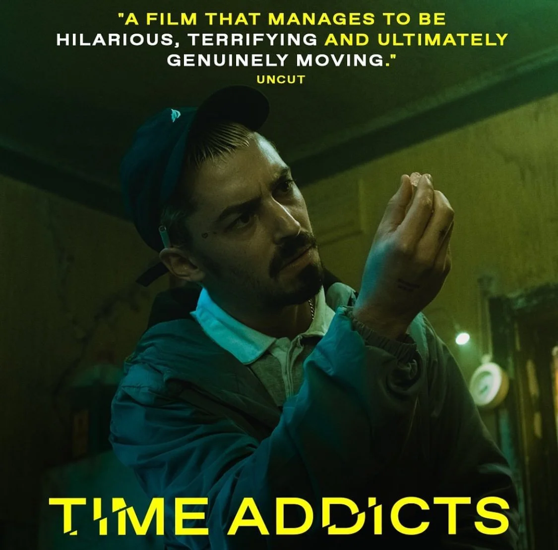 Poster for the film 'Time Addicts' featuring a man with a mustache and beard, wearing a cap and jacket, looking thoughtful with his hand near his face. The poster includes a quote about the film being hilarious and moving, and the title 'Time Addicts