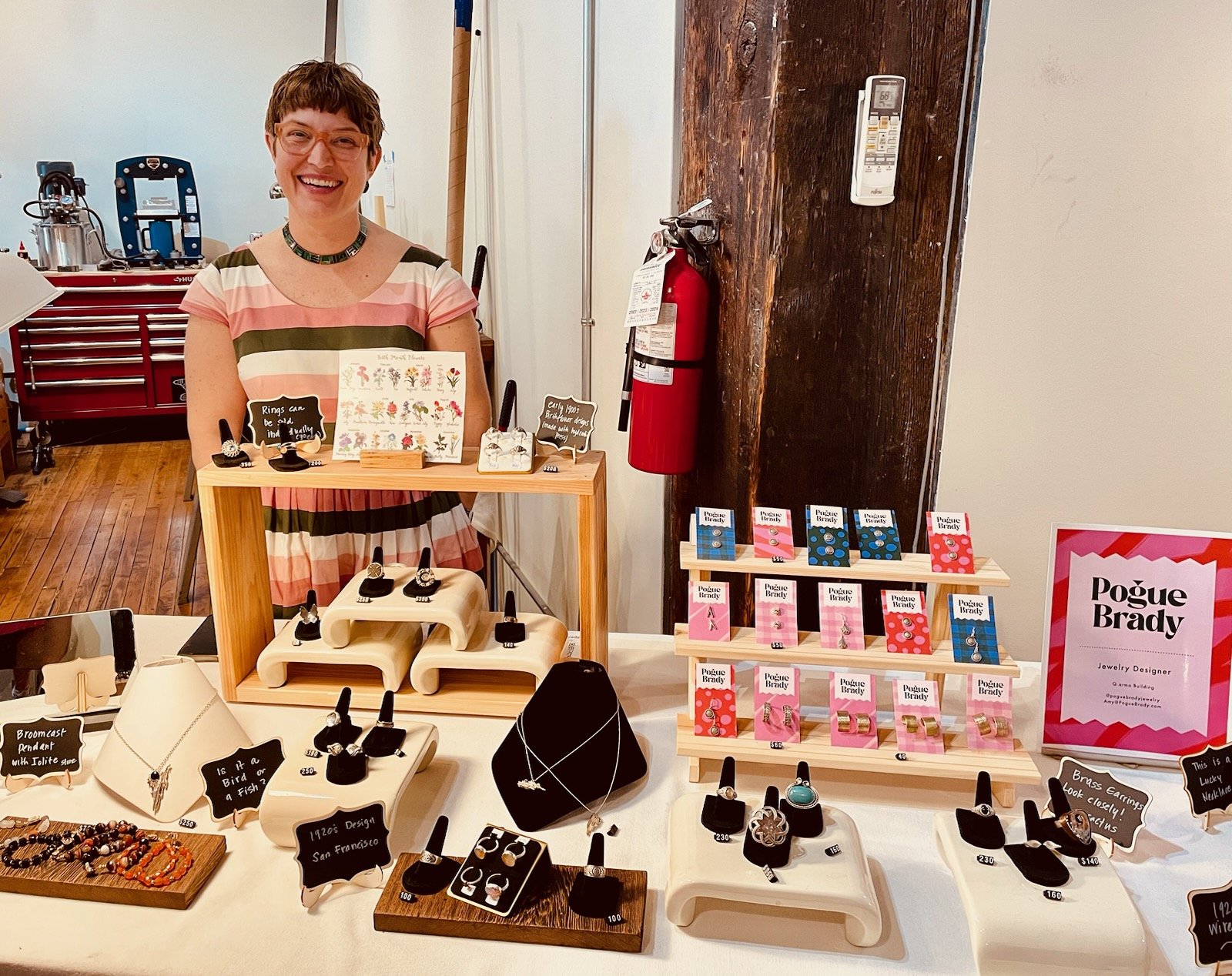 Photo of artist next to her jewelry