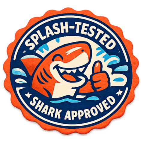 A round badge with a cartoon shark giving a thumbs up, surrounded by water and waves. The badge reads 'Splash-Tested Shark Approved.'