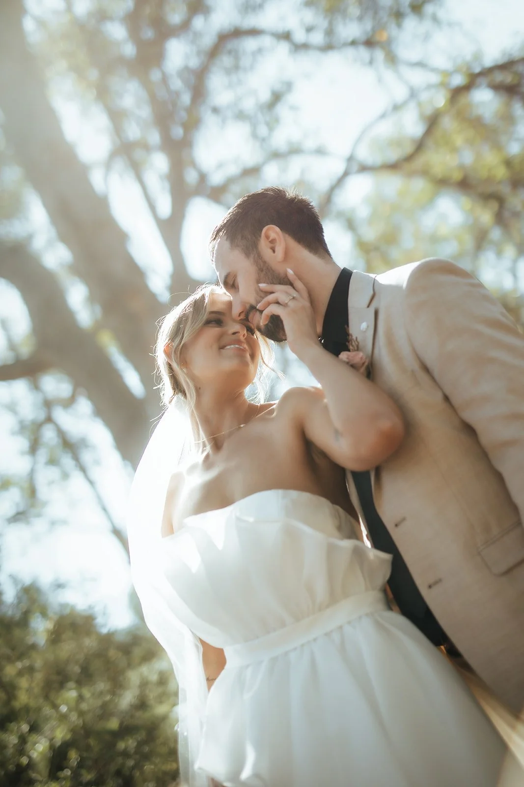 Bride and Groom on their elopement day at Bina Maya Retreat in Quedjinup W.A smiling at one another under the trees in perfect lighting