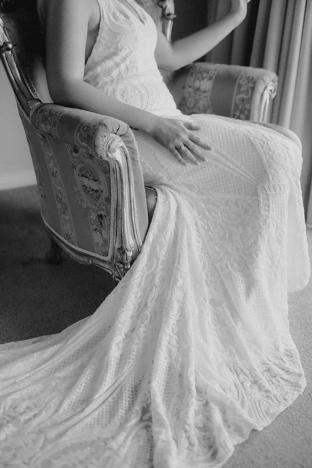 Bride in her wedding gown sitting on an upholstered vintage chair by a window on her elopement day in Dunsborough W.A