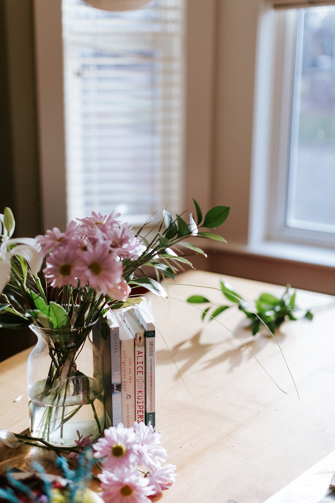 Alice Kuipers books leaning against flowers in a vase