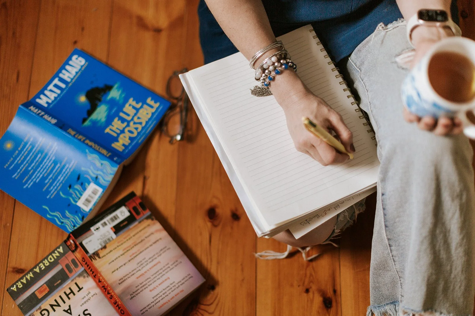 Alice Kuipers author writing on notebook and holding a cup of tea