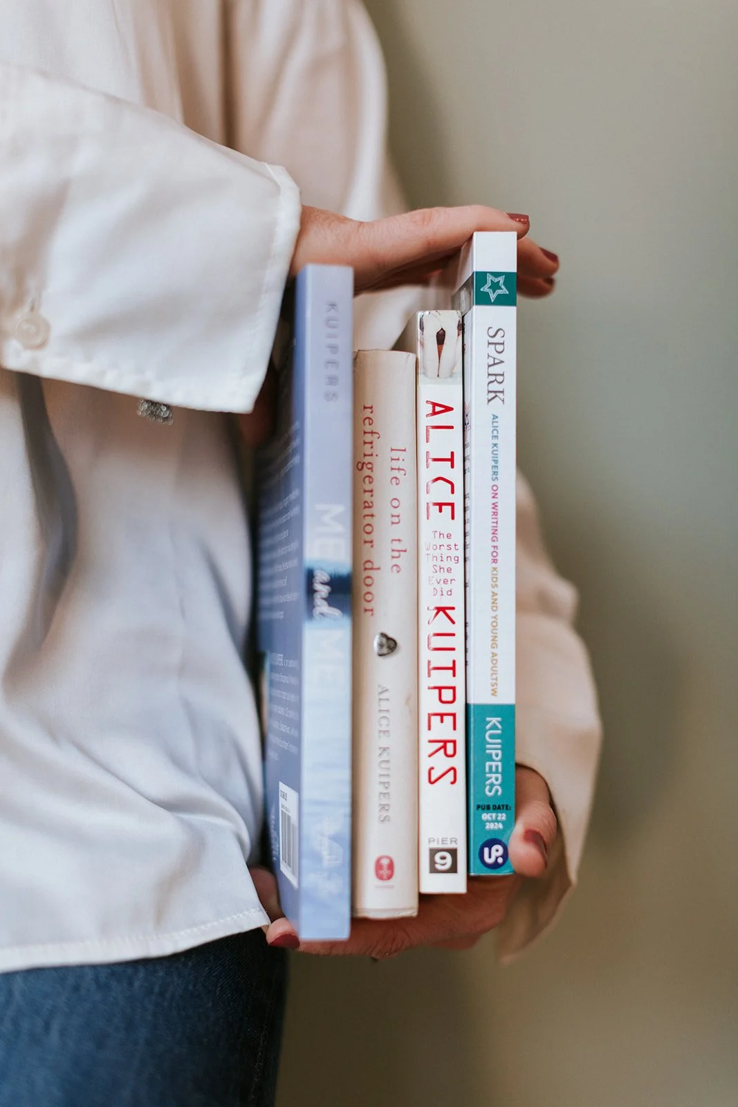 Alice Kuipers author holding up her books by her side