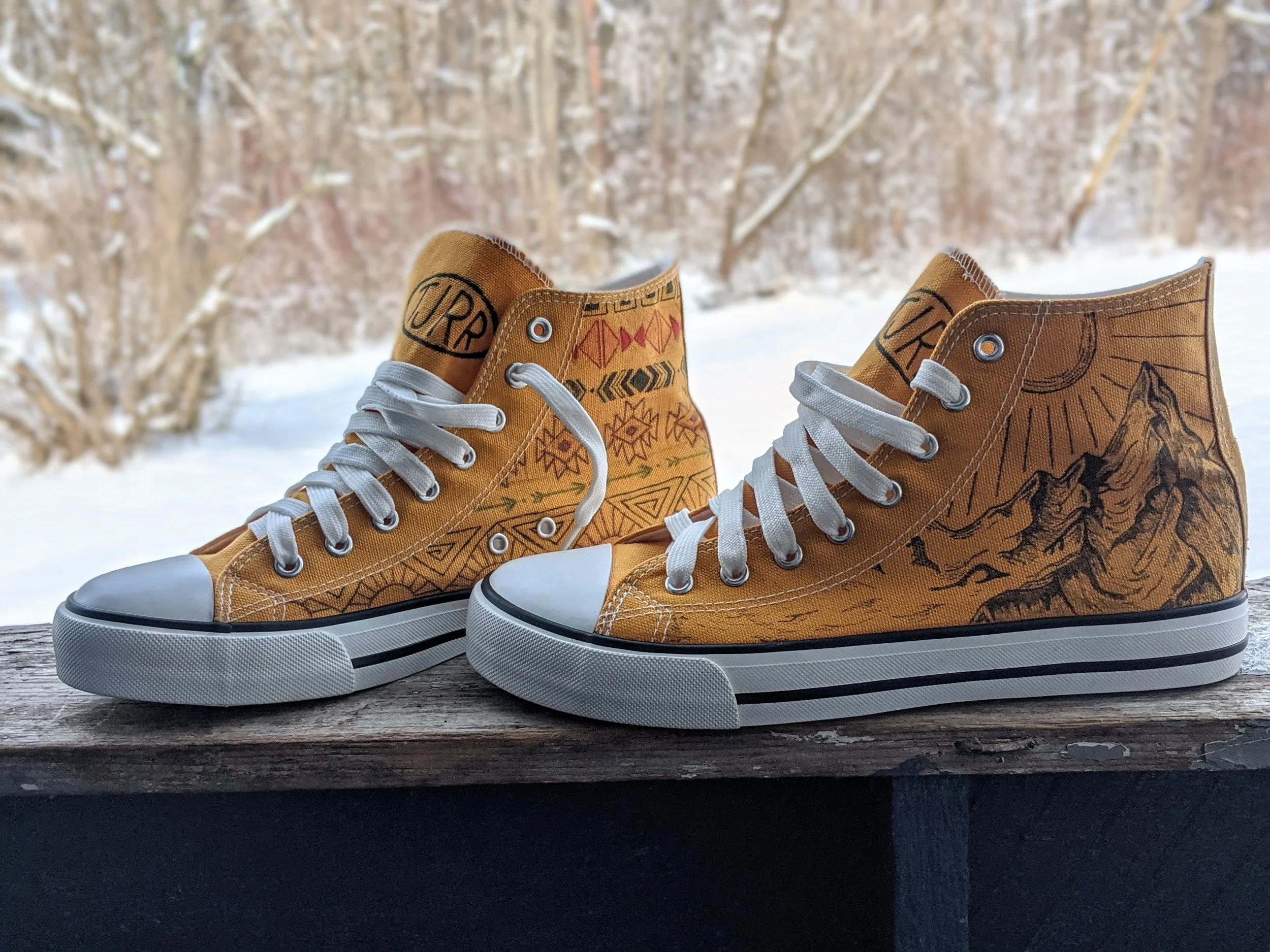 Yellow canvas sneakers with mountain illustrations, and tribal patterns.