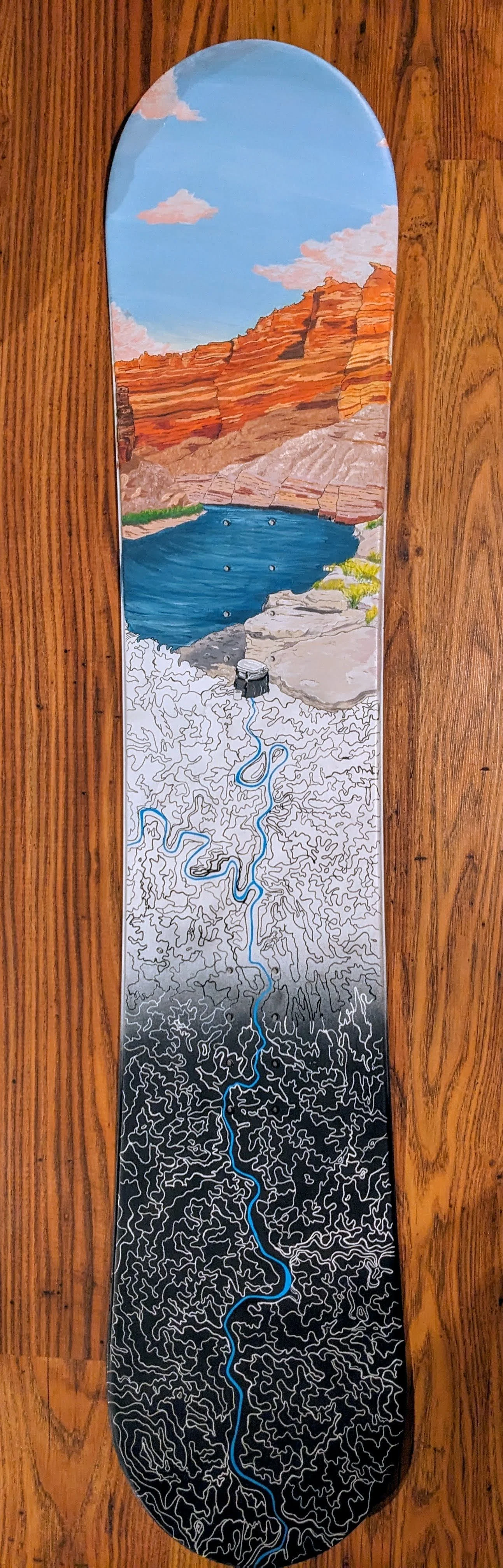 Painted snowboard of cataract canyon ledge camp with topographic map of river section underneath