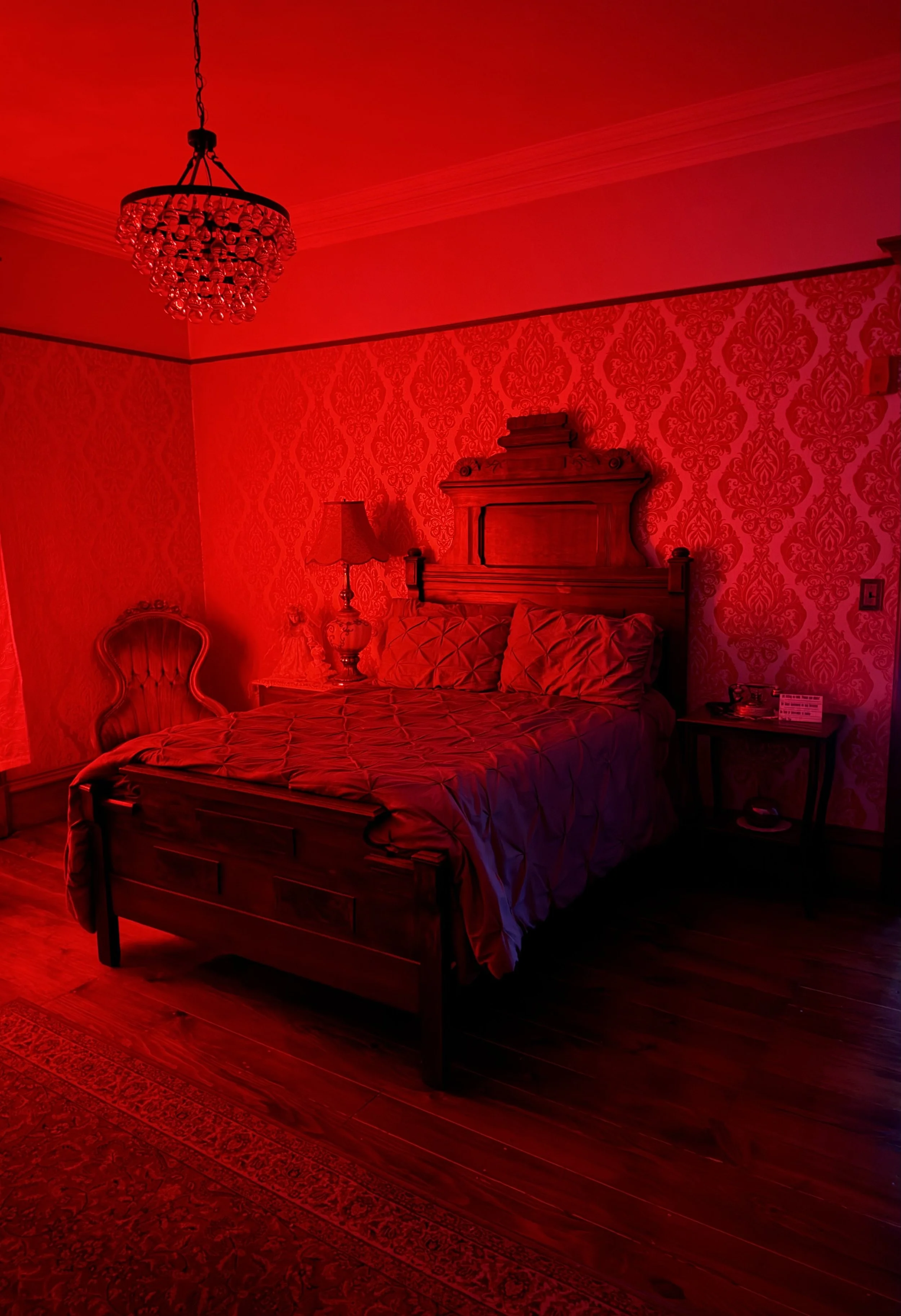 A tall, Victorian-style house painted in shades of blue with detailed trim and multiple bay windows, under a clear blue sky.