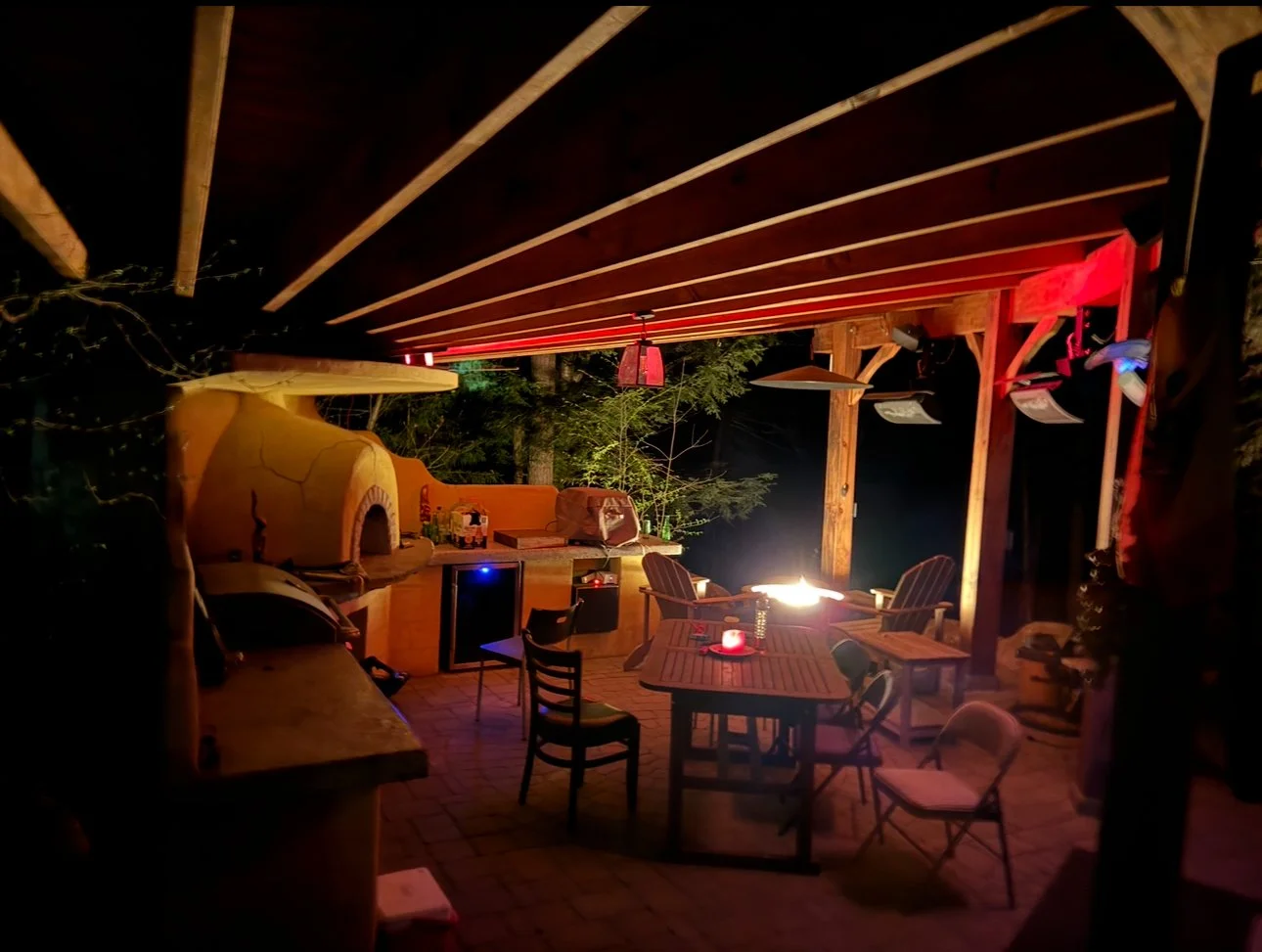 Outdoor Kitchen build with Wood Fired Oven and poured cement polished countertops, Bromic outdoor heaters, cement pavers, Plastered wall, timber frame with 36 ft curved carrying beam. Installed Sonos sound system with sub-woofer.