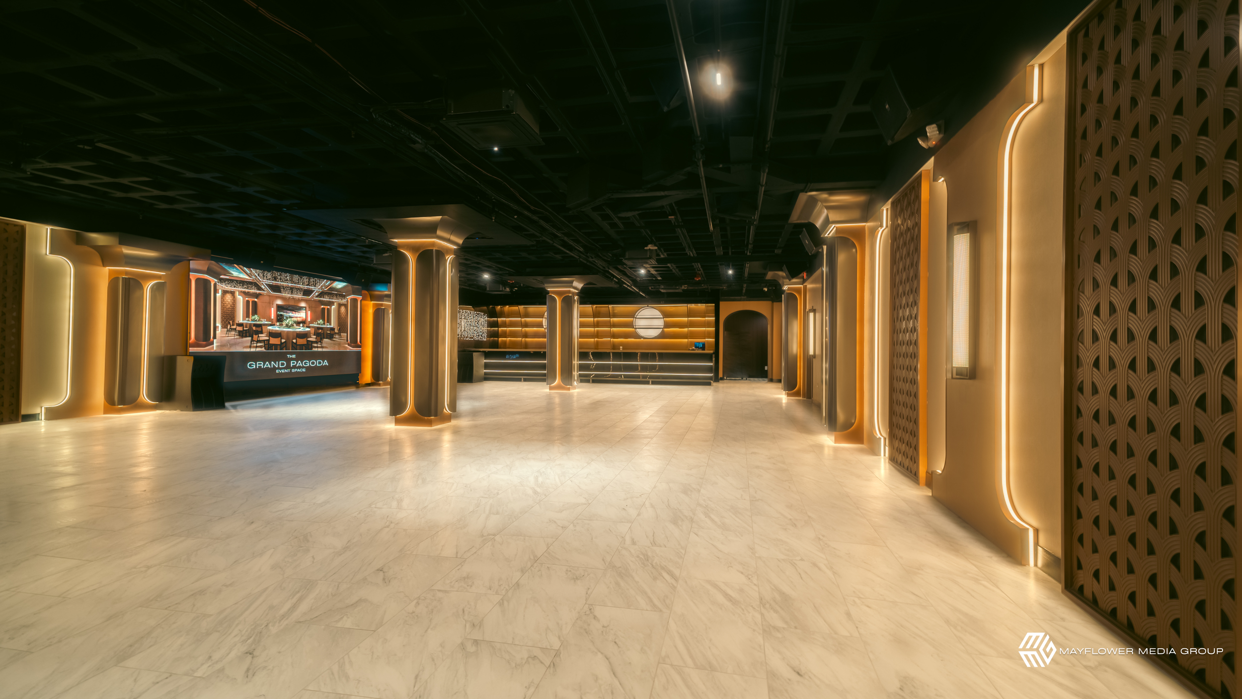 Empty event space with modern design, illuminated walls, columns with lighting, and a large screen displaying 'Grand Pagoda Event Space'.