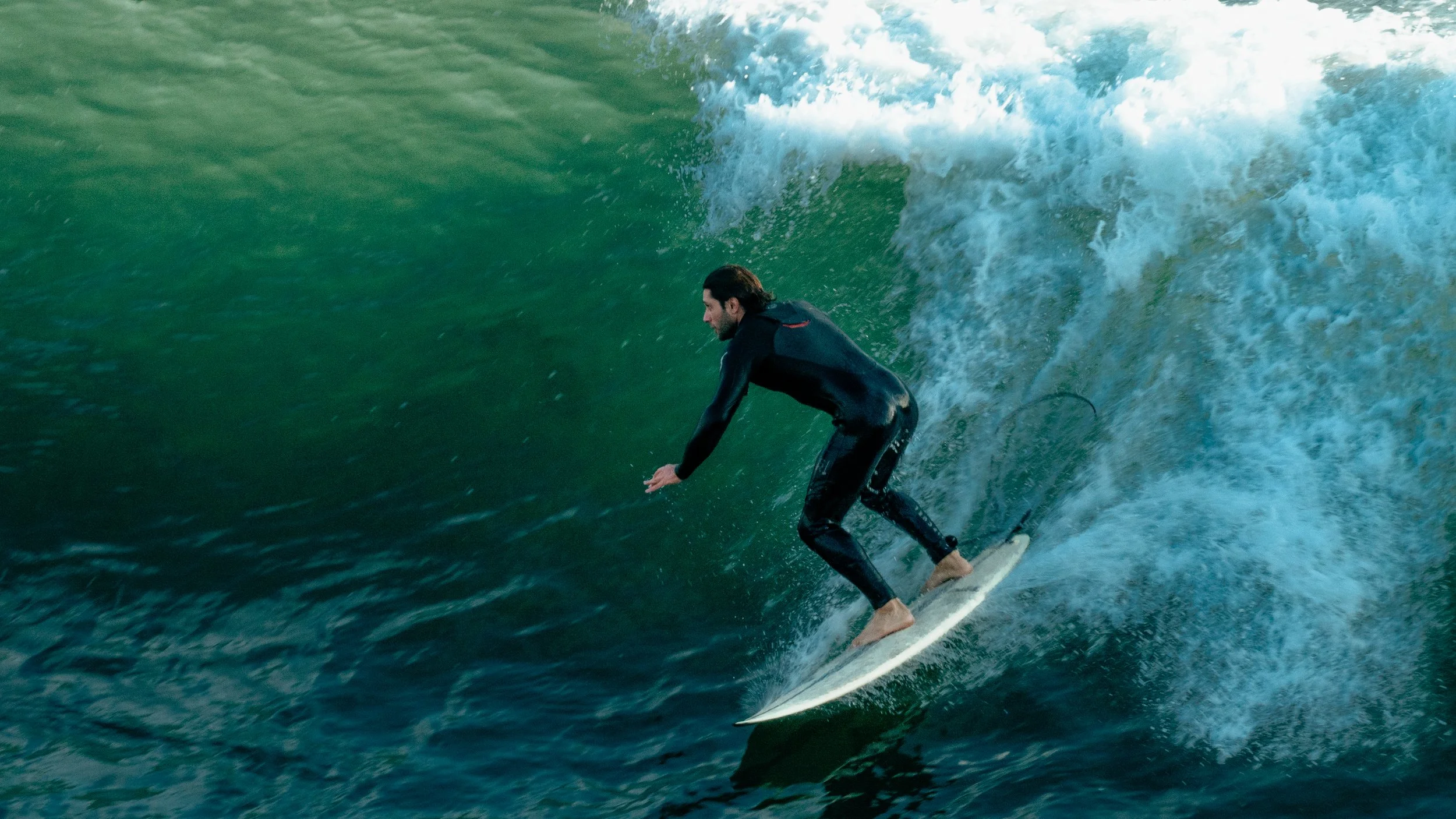 A man surfing on a large wave in the ocean.