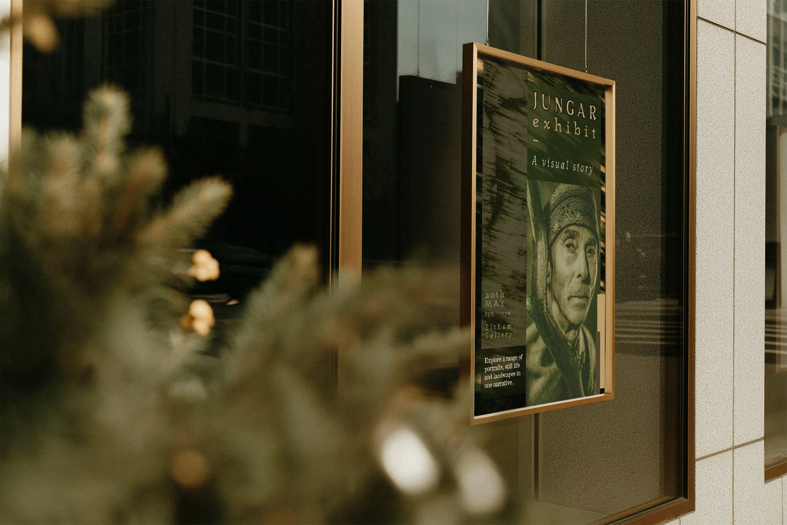 A framed poster advertising the Jungar exhibit, featuring a portrait of a person wearing a helmet. The poster includes details about the exhibit date, time, and location, with the tagline 'A visual story.'