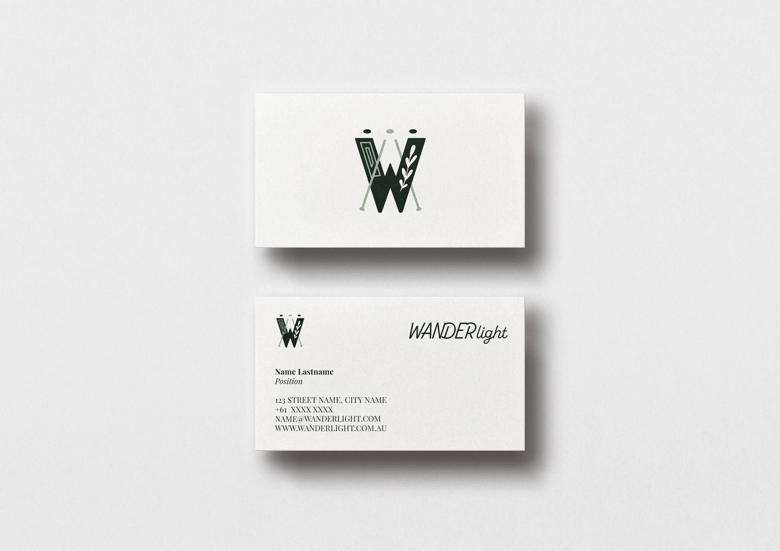 A set of white business materials, including a card and a letterhead, both featuring a black logo of stylized letters 'W' with decorative elements, on a light background.