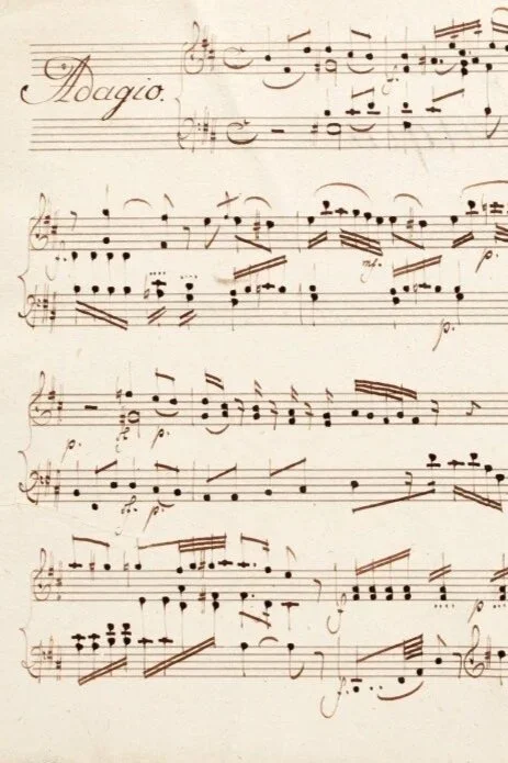 Handwritten sheet music with the tempo marking "Adagio" at the top.