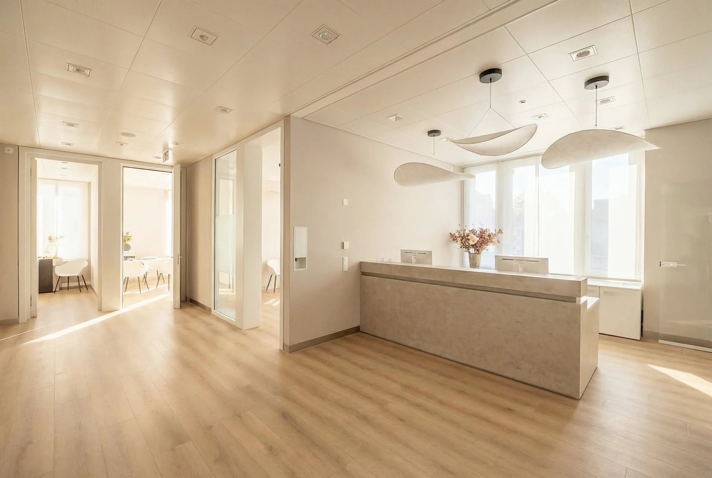 Modern office reception area with white walls, large windows, green plants, a white desk, and minimalist decor.