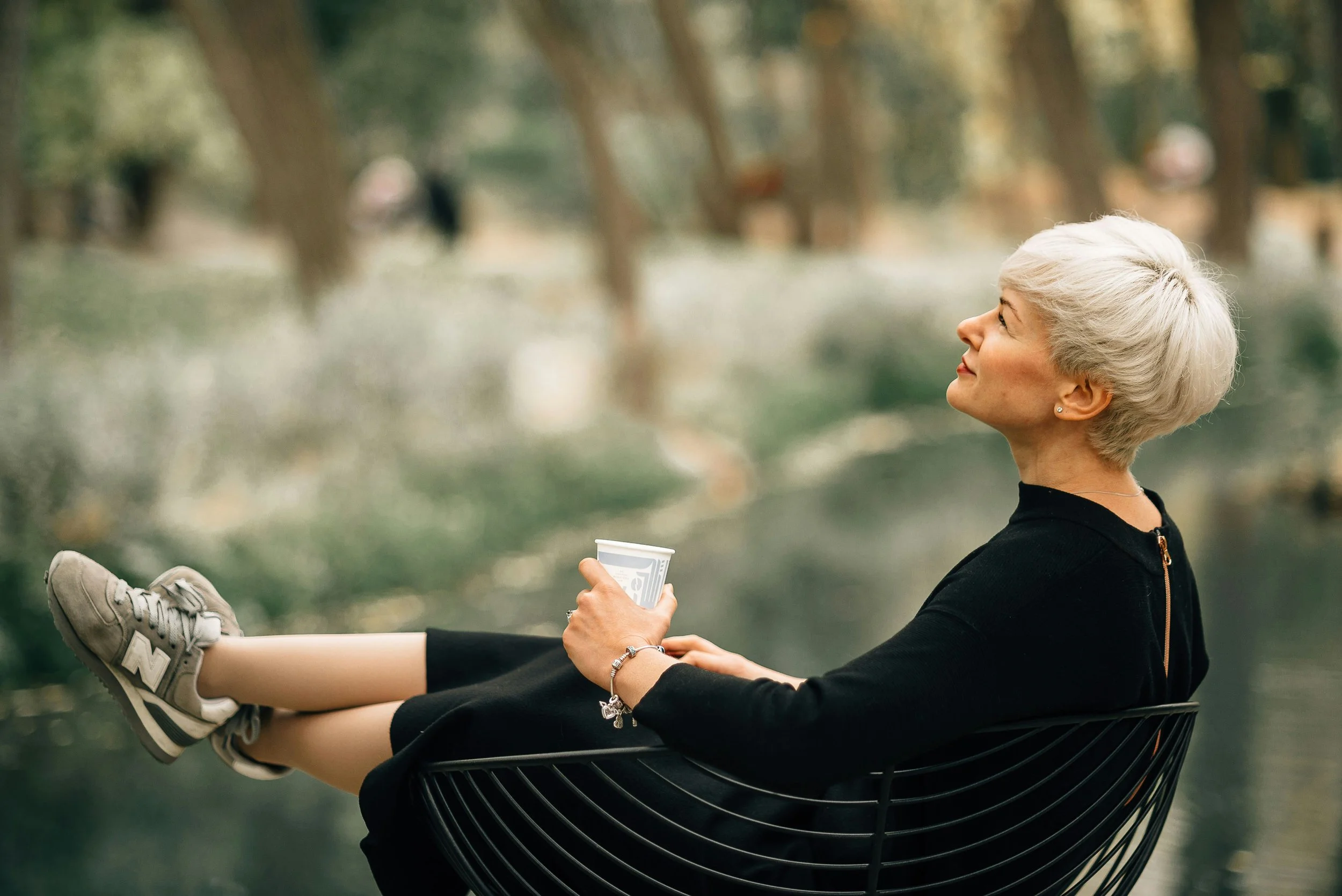 thoughtful midlife woman reclining with a drink - representing my therapy services for Identity and codependency