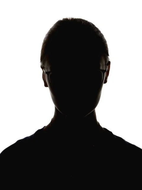 Silhouette of a person with glasses against a light background.