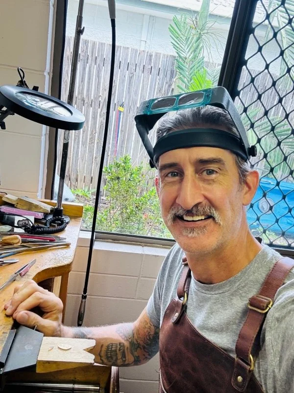 Master jeweller smiling at his work bench