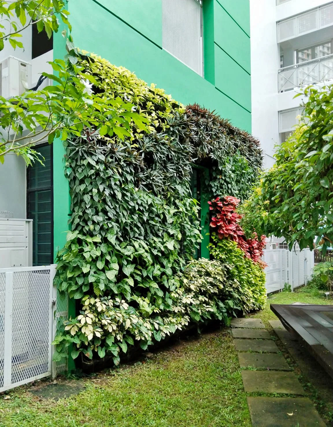 Building exterior with a green wall at an outdoor grassy area.