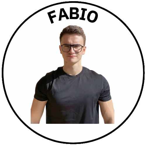 Portrait of a man with a beard and bald head, wearing a graphic T-shirt, crossing his arms, with a white background and the name 'Andrea' in black text above him.