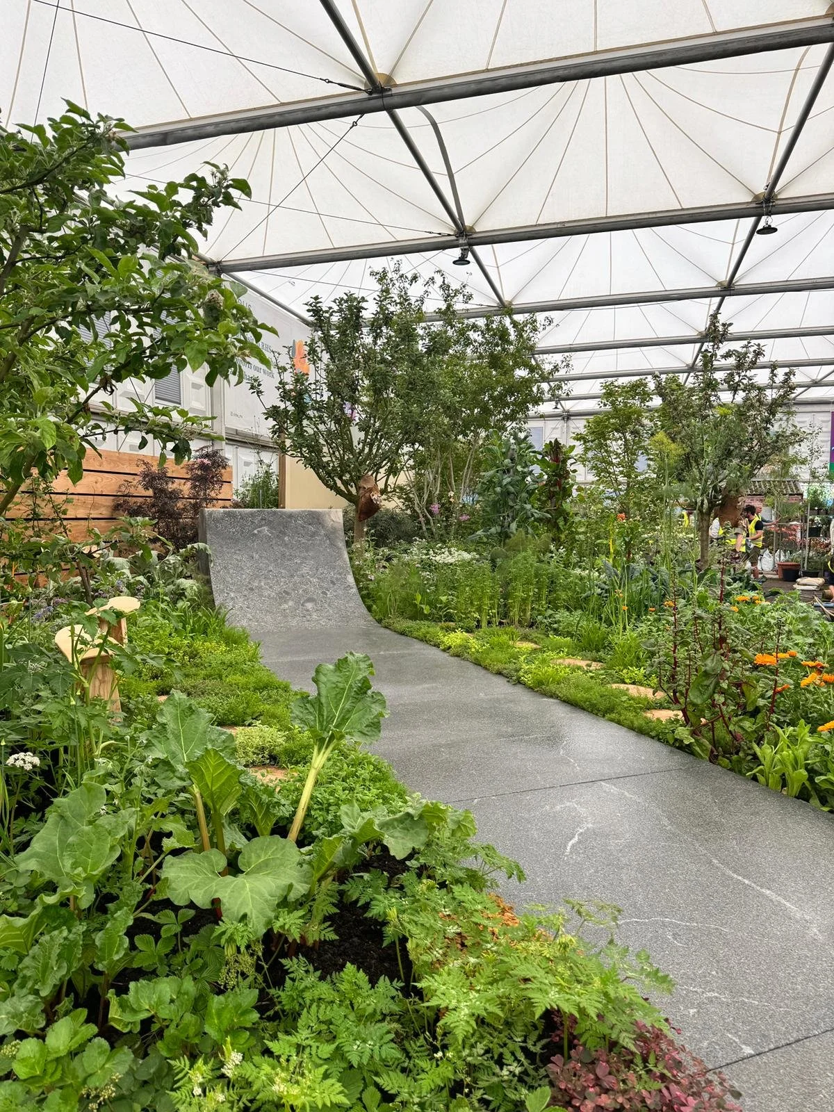Edible skatepark with lush green plants, trees, and flowering plants, installation for RHS Chelsea Show 2024.