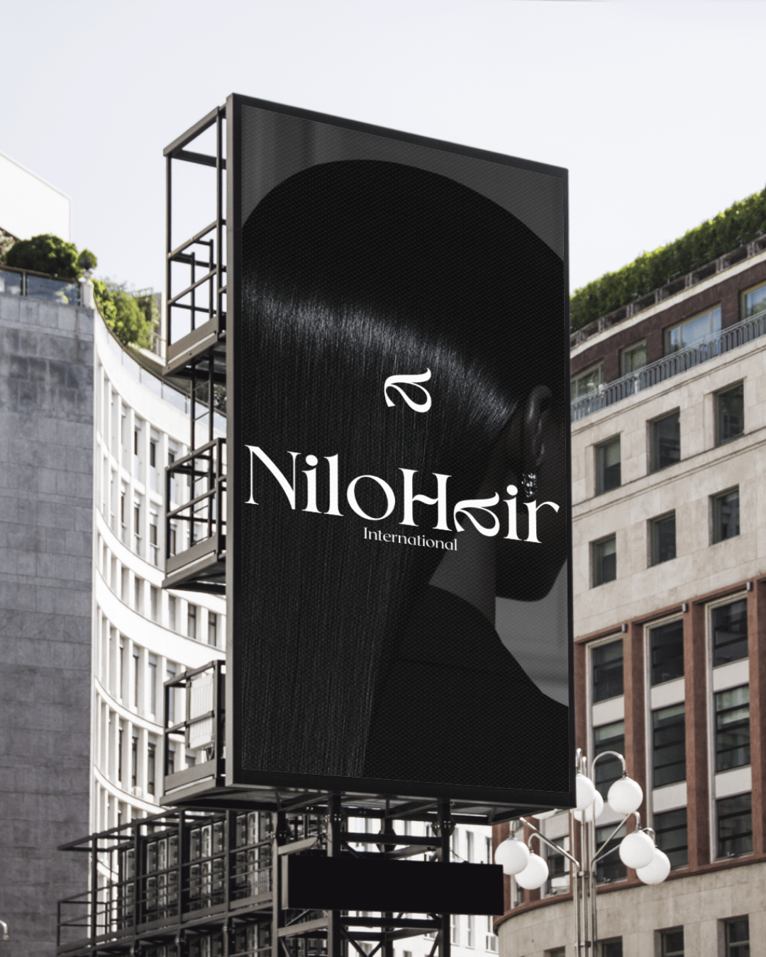 Outdoor digital billboard displaying the logo of Nilohir International, with a silhouette of a person's profile in the background, in an urban setting.