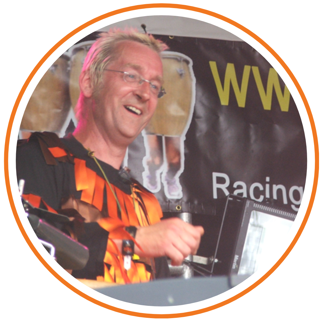 Paul, founder of Drum Runners standing in front of a Drum Runners banner