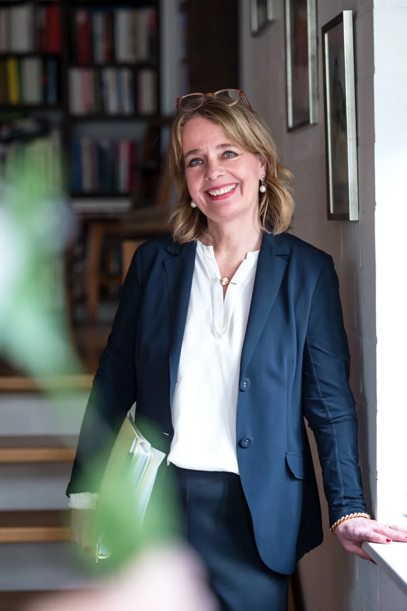 Friederike von Schönfeldt, lächelnd vor einer Bücherwand.