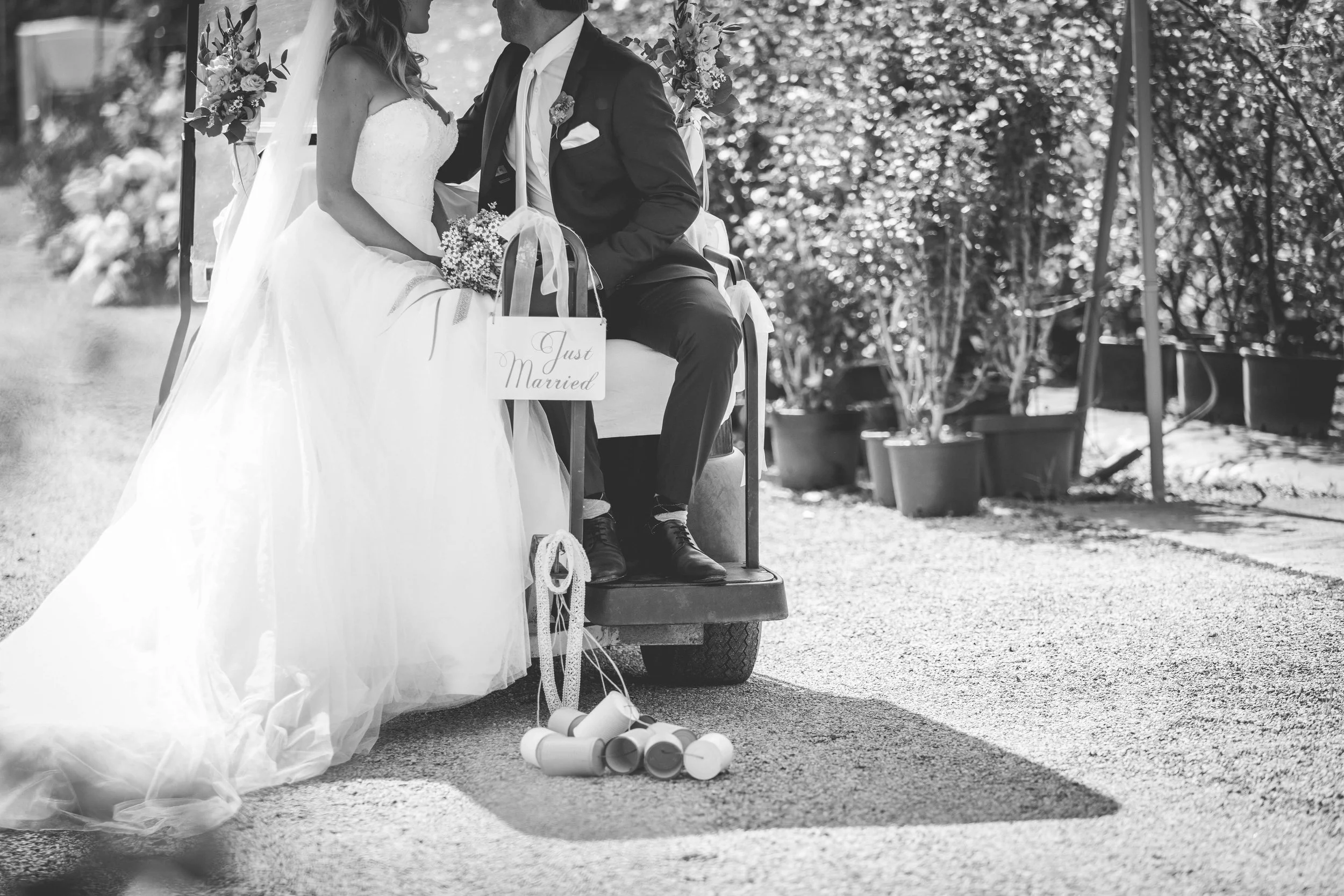 Lauries Kundinnen Mariana und Carmen halten an ihrem Hochzeitstag auf einer grünen Wiese Händchen.