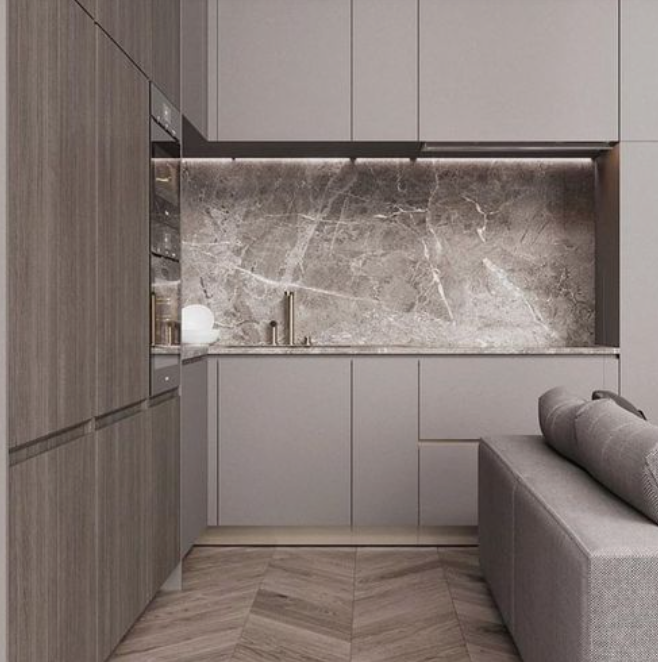 Modern kitchen with gray cabinets, a marble backsplash, and a gray sofa with a pillow.