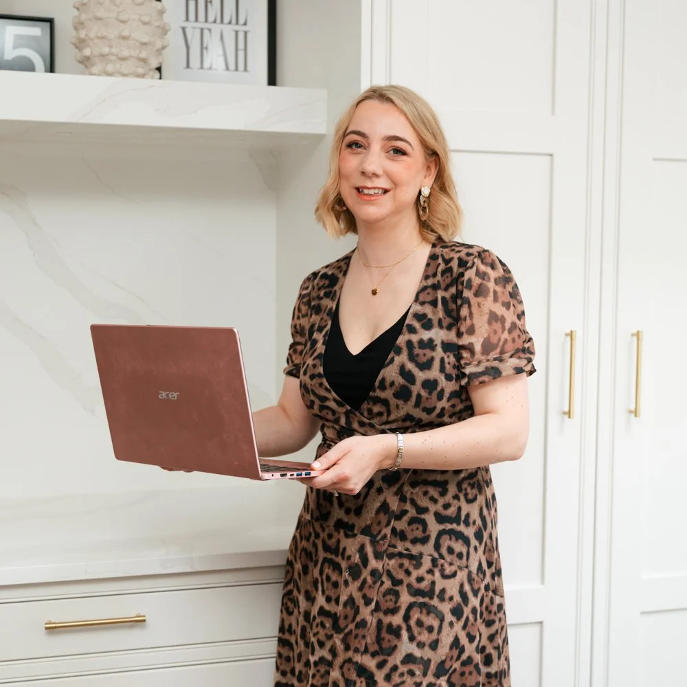 Cat, a woman with shoulder-length blonde hair, wearing a leopard print dress with puffed sleeves